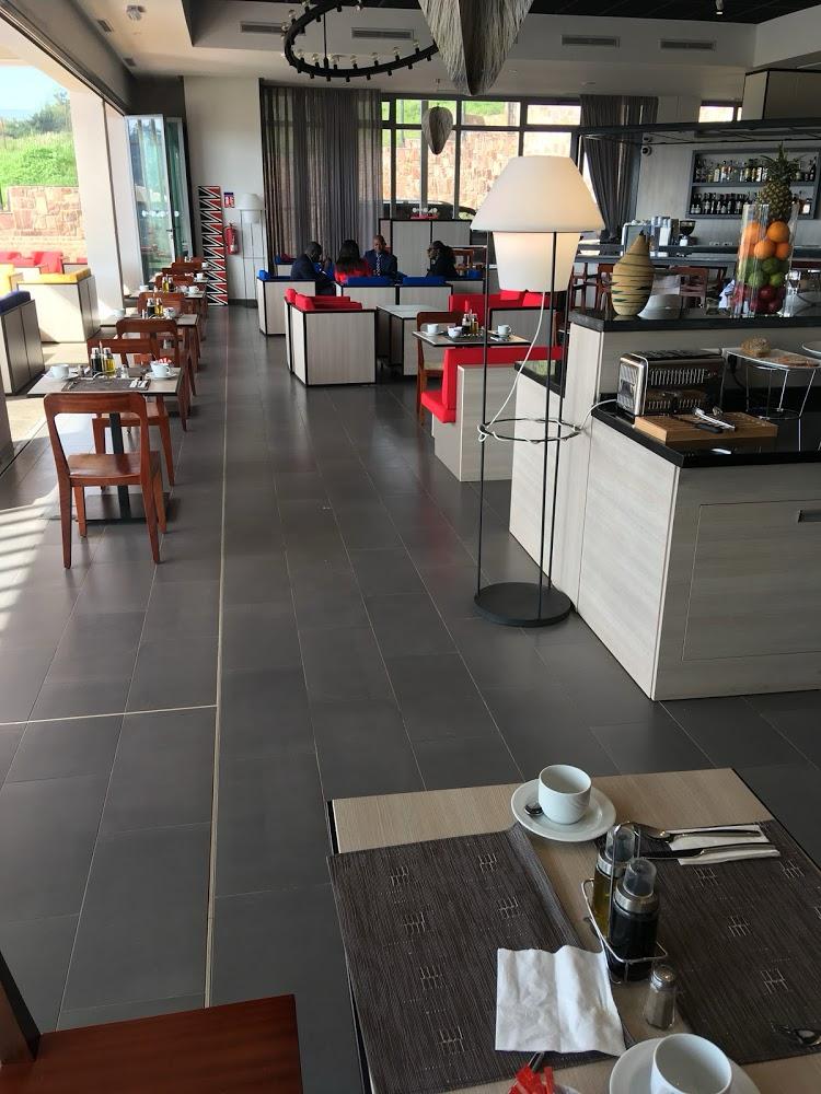 Onomo Hotel Kigali's modern indoor bar and dining area. Designed by Cesare Ricchetti, it features a 19-metre folding glass wall that opens onto the outdoor space